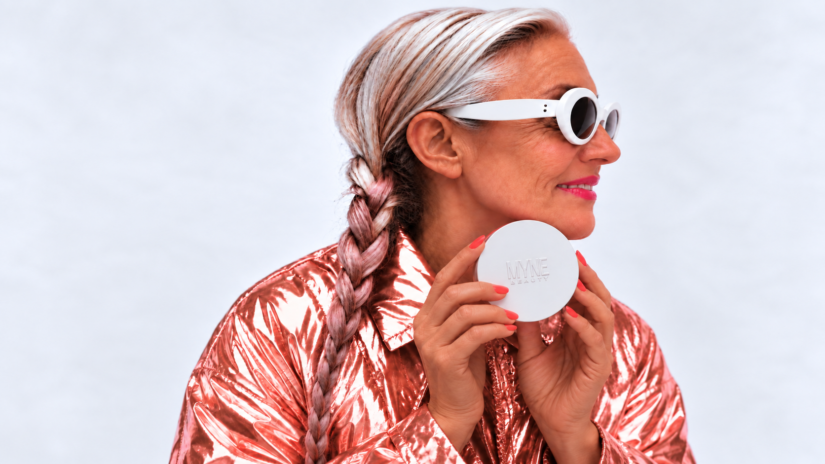 Woman in white sculptural glasses holding the Haute Flash compact, t1