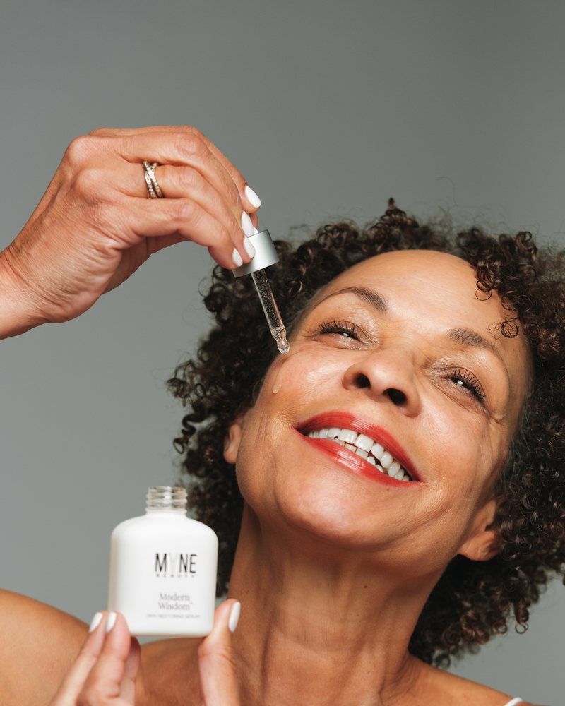 Woman applying Modern Wisdom serum with the dropper, t1
